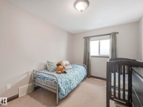Bedroom featuring light carpet and a textured ceiling - 960 Summerside Link, Edmonton, AB - Indoor Photo Showing Bedroom