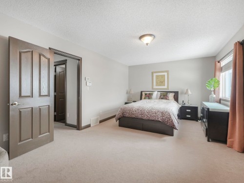 Bedroom with light colored carpet and a textured ceiling - 960 Summerside Link, Edmonton, AB - Indoor Photo Showing Bedroom