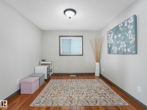 Empty room with dark wood finished floors and a textured ceiling - 960 Summerside Link, Edmonton, AB - Indoor Photo Showing Other Room