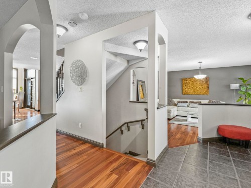 Hall featuring arched walkways, dark wood-style floors, and a textured ceiling - 960 Summerside Link, Edmonton, AB - Indoor Photo Showing Other Room