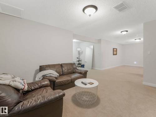 Living area featuring carpet floors and a textured ceiling - 960 Summerside Link, Edmonton, AB - Indoor