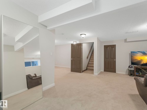 Finished below grade area featuring a textured ceiling and light colored carpet - 960 Summerside Link, Edmonton, AB - Indoor