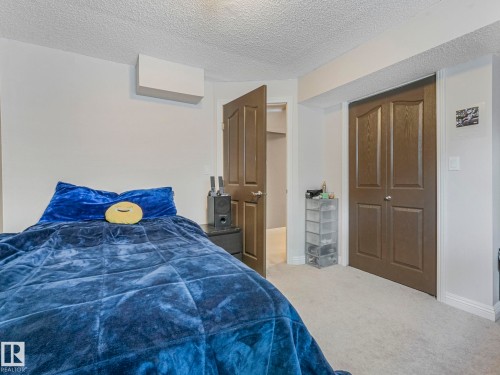 Bedroom with carpet, a textured ceiling, and a closet - 960 Summerside Link, Edmonton, AB - Indoor Photo Showing Bedroom