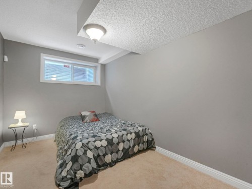 Carpeted bedroom with baseboards and a textured ceiling - 960 Summerside Link, Edmonton, AB - Indoor Photo Showing Bedroom