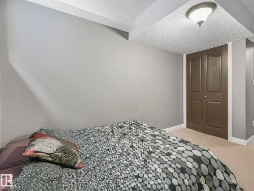 Bedroom featuring carpet floors, a textured ceiling, and a closet - 960 Summerside Link, Edmonton, AB - Indoor Photo Showing Bedroom