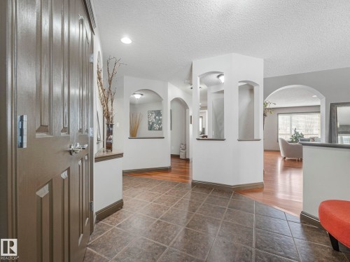 Entrance foyer with arched walkways, a textured ceiling, and dark tile patterned flooring - 960 Summerside Link, Edmonton, AB - Indoor Photo Showing Other Room