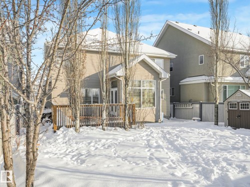 Snow covered back of property featuring a deck, a shed, and stucco siding - 960 Summerside Link, Edmonton, AB - Outdoor