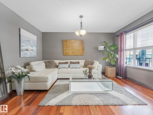 Living area with hardwood / wood-style flooring and a textured ceiling - 960 Summerside Link, Edmonton, AB - Indoor Photo Showing Living Room