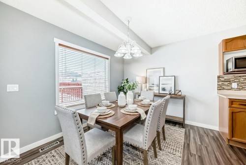 Dining space with a chandelier, dark wood finished floors, and beam ceiling - 3208 29 Avenue, Edmonton, AB - Indoor Photo Showing Dining Room