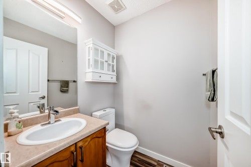 Half bath featuring vanity and dark wood finished floors - 3208 29 Avenue, Edmonton, AB - Indoor Photo Showing Bathroom