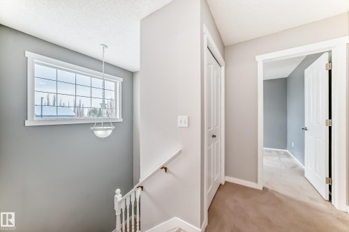 Corridor with an upstairs landing, light carpet, and a textured ceiling - 3208 29 Avenue, Edmonton, AB - Indoor Photo Showing Other Room