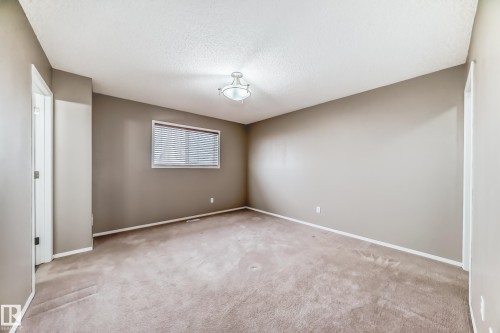 Unfurnished room featuring light carpet and a textured ceiling - 3208 29 Avenue, Edmonton, AB - Indoor Photo Showing Other Room