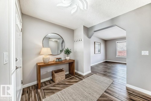 Hall with dark wood-style flooring, arched walkways, and a textured ceiling - 3208 29 Avenue, Edmonton, AB - Indoor Photo Showing Other Room