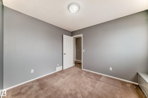 Spare room featuring light carpet and a textured ceiling - 3208 29 Avenue, Edmonton, AB - Indoor Photo Showing Other Room