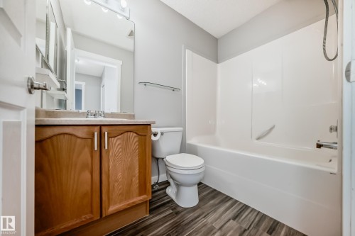 Bathroom with vanity, shower / bathtub combination, and dark wood-type flooring - 3208 29 Avenue, Edmonton, AB - Indoor Photo Showing Bathroom