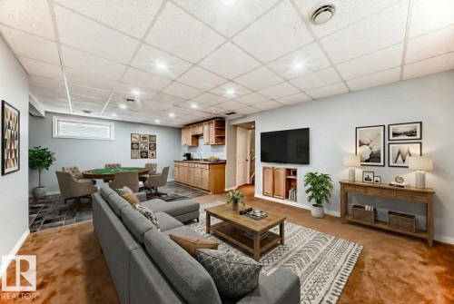 Carpeted living room with a drop ceiling and baseboards - 3208 29 Avenue, Edmonton, AB - Indoor Photo Showing Basement