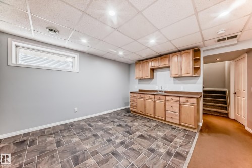 Kitchen featuring a drop ceiling, light wood finish cabinets, open shelves, dark countertops, and recessed lighting - 3208 29 Avenue, Edmonton, AB - Indoor