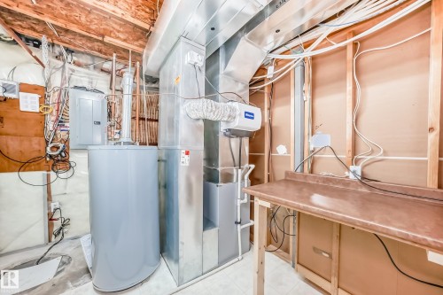 Utility room featuring electric panel, water heater, and heating unit - 3208 29 Avenue, Edmonton, AB - Indoor Photo Showing Basement