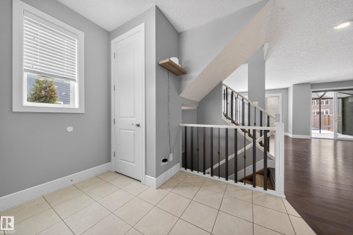 Stairway with plenty of natural light, tile patterned flooring, and a textured ceiling - 1907 Adamson Terrace, Edmonton, AB - Indoor Photo Showing Other Room