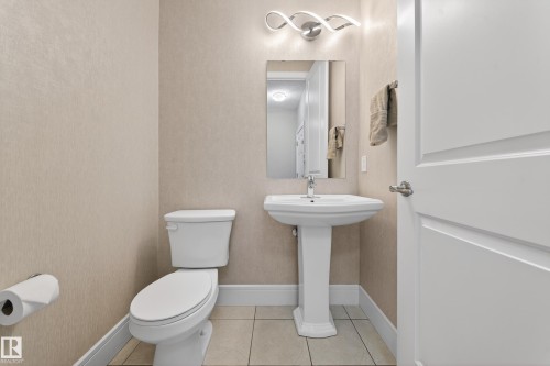 Bathroom with toilet and light tile patterned floors - 1907 Adamson Terrace, Edmonton, AB - Indoor Photo Showing Bathroom