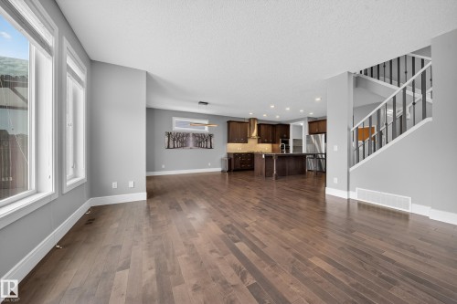 Unfurnished living room with dark wood-type flooring, recessed lighting, and a textured ceiling - 1907 Adamson Terrace, Edmonton, AB - Indoor