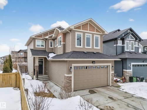 Craftsman house with an attached garage, driveway, a shingled roof, and stone siding - 1907 Adamson Terrace, Edmonton, AB - Outdoor With Facade