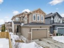 Craftsman house with an attached garage, driveway, a shingled roof, and stone siding - 1907 Adamson Terrace, Edmonton, AB  - Outdoor With Facade 
