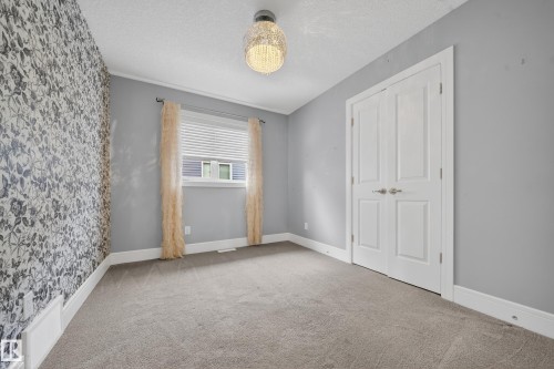 Unfurnished bedroom with a textured ceiling and carpet floors - 1907 Adamson Terrace, Edmonton, AB - Indoor Photo Showing Other Room