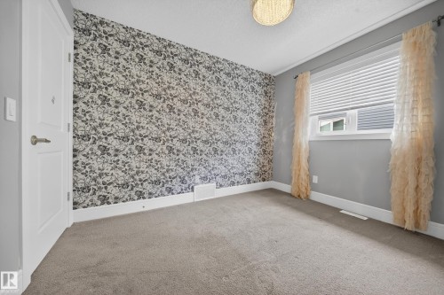 Unfurnished room featuring wallpapered walls, light colored carpet, and a textured ceiling - 1907 Adamson Terrace, Edmonton, AB - Indoor Photo Showing Other Room