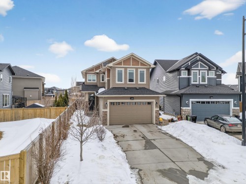 Craftsman inspired home with stone siding, a residential view, a garage, and driveway - 1907 Adamson Terrace, Edmonton, AB - Outdoor With Facade