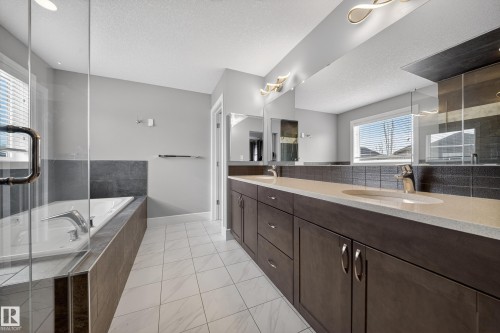 Bathroom featuring double vanity, a shower stall, a garden tub, and a textured ceiling - 1907 Adamson Terrace, Edmonton, AB - Indoor Photo Showing Bathroom