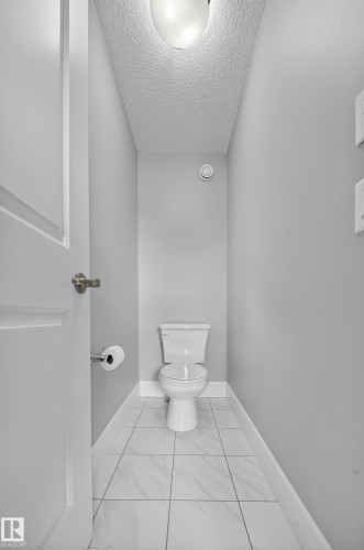 Bathroom with a textured ceiling and light marble finish floors - 1907 Adamson Terrace, Edmonton, AB - Indoor Photo Showing Bathroom