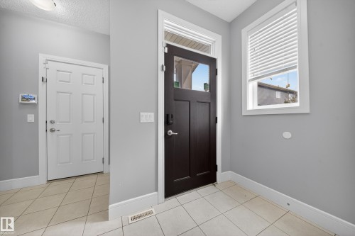 Foyer entrance featuring a textured ceiling and light tile patterned floors - 1907 Adamson Terrace, Edmonton, AB - Indoor Photo Showing Other Room