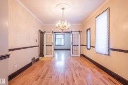 Unfurnished dining area with a barn door, a chandelier, crown molding, and light wood-style floors - 