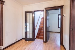 Spare room featuring stairs, crown molding, and light wood finished floors - 