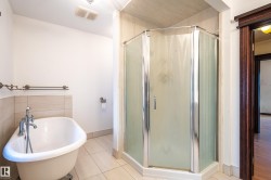 Full bathroom featuring a freestanding bath, a stall shower, and light tile patterned floors - 