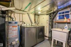 Laundry room featuring finished concrete flooring, water heater, and washer and dryer - 
