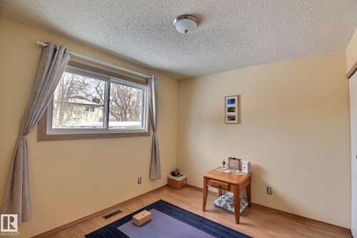 Bedroom with a closet featuring light laminate  flooring and a textured ceiling - 4520 20A Avenue, Edmonton, AB - Indoor