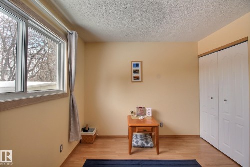 Bedroom with light laminate  flooring, a textured ceiling, and a closet - 4520 20A Avenue, Edmonton, AB - Indoor Photo Showing Other Room
