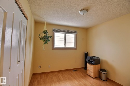 Bedroom featuring light laminate  flooring, a closet, and a textured ceiling - 4520 20A Avenue, Edmonton, AB - Indoor Photo Showing Other Room