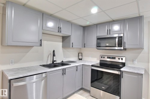 2nd Kitchen with gray cabinets, stainless steel appliances, light countertops, and a paneled ceiling - 4520 20A Avenue, Edmonton, AB - Indoor Photo Showing Kitchen With Double Sink With Upgraded Kitchen