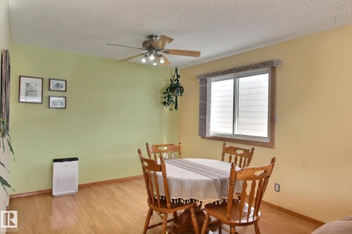Dining area with light laminate  floors, a textured ceiling, and a ceiling fan - 4520 20A Avenue, Edmonton, AB - Indoor Photo Showing Dining Room