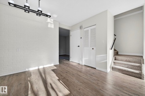 Unfurnished living room featuring brick wall and wood finished floors - 9969 171 Avenue, Edmonton, AB - Indoor Photo Showing Other Room