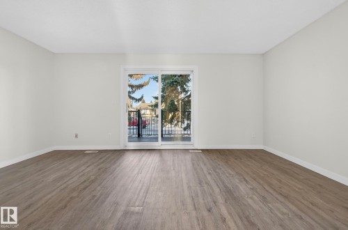 Empty room with dark wood-style flooring and baseboards - 9969 171 Avenue, Edmonton, AB - Indoor
