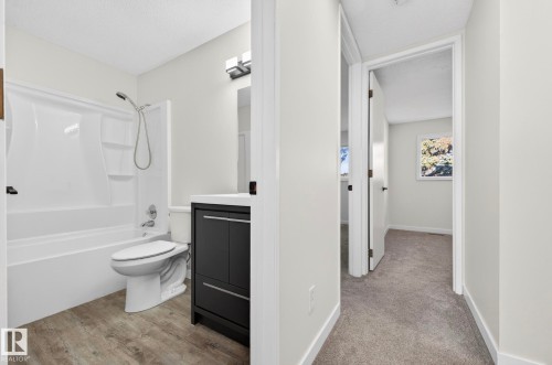 Full bathroom featuring vanity, shower / tub combination, a textured ceiling, and light carpet - 9969 171 Avenue, Edmonton, AB - Indoor Photo Showing Bathroom