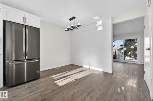 Unfurnished dining area with dark wood-style flooring and a chandelier - 9969 171 Avenue, Edmonton, AB - Indoor