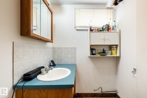 Half bath in basement featuring vanity and tasteful backsplash - 12231 47 Street, Edmonton, AB - Indoor Photo Showing Bathroom