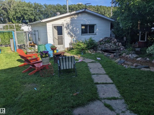 Backyard in summer featuring an outdoor fire pit, a patio area and fountain - 12231 47 Street, Edmonton, AB - Outdoor