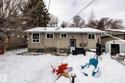 Snow covered house featuring a storage unit and stucco siding - 12231 47 Street, Edmonton, AB - Outdoor