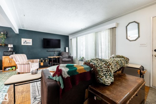 Living area featuring a textured ceiling and large picture window - 12231 47 Street, Edmonton, AB - Indoor